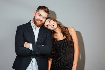 Smiling couple in smart wear embracing and looking at camera