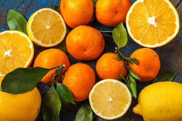 Healthy fresh citrus juice (two glasses), oranges, tangerines, lemons, ice, leaves.  Love for a healthy raw food concept
