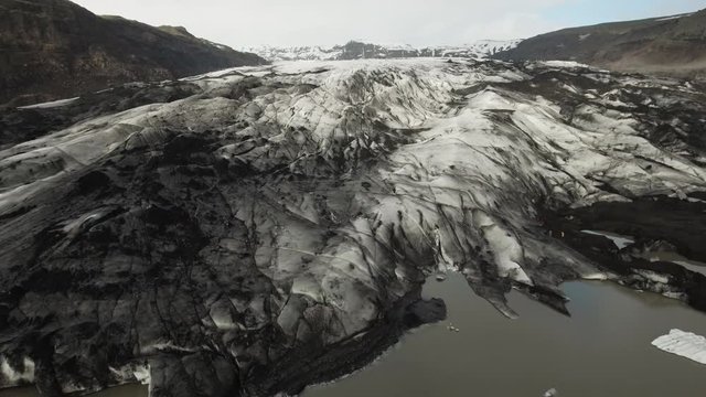 Drone footage of Solheimajokull glacier covered with black volcanic ash

