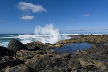 Waves rolling in at the Atlantic ocean, smashing on cliffs produ