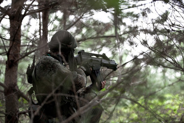 military woman with gun in ambush.