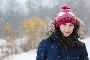 Girl in white snowy forest during beautiful snowfall