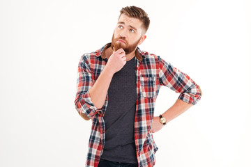 Portrait of a thoughtful bearded man standing and looking away