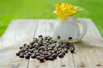Obraz na płótnie Canvas Coffee beans on grunge wood background with Ixora flower pot and