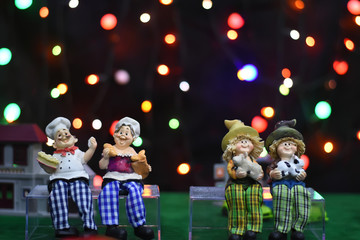 Blurred image : family dolls sit with smile together. colorful gift box For Christmas and Happy New Year on colorful background.