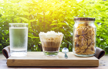 Coffee with whipping cream with breakfast cereal and glass of water 