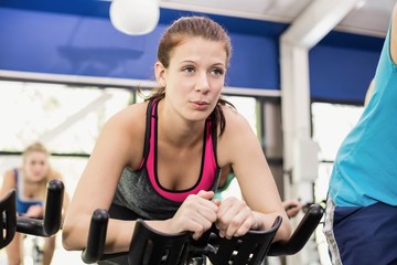 Fototapeta premium Fit group of people using exercise bike together
