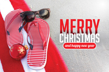 Merry Christmas from a tropical climate. Flip flops on the beach. For Christmas in June, July, August, December. Christmas card with copy space. - 128064945