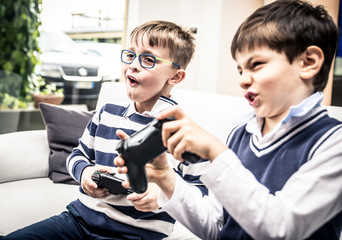 Happy children playing videogames in the living room