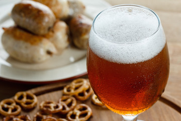 Beer glass with german pretzel and sausage