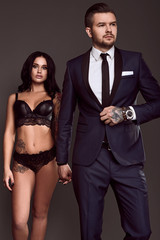 Portrait of a brutal man in suit and sexy girl