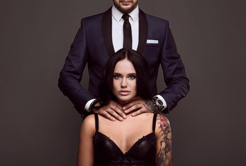Portrait of a brutal man in suit and sexy girl