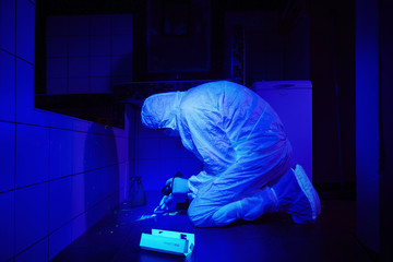 Criminologist working on DNA evidence under UV light