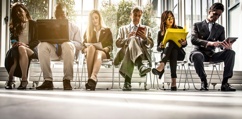 Row of business people waiting for an interview