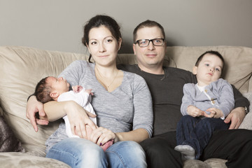 Young happy family with two children at home