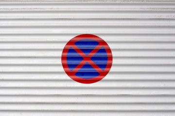 Closed garage entrance door with forbidden parking sign on outsi