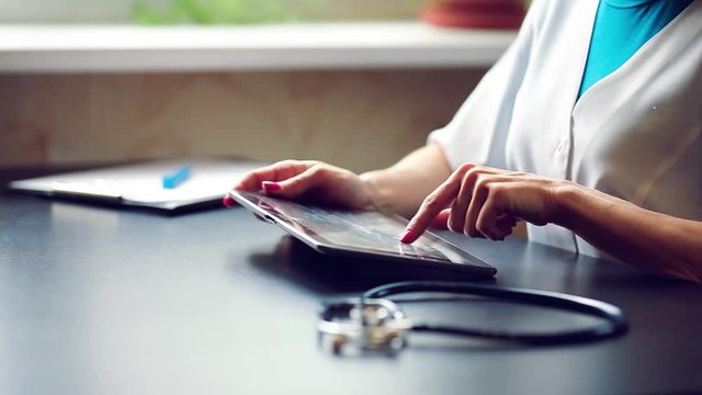 Woman doctor using tablet computer in hospital