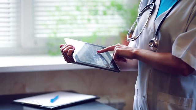 Woman doctor using tablet computer in hospital