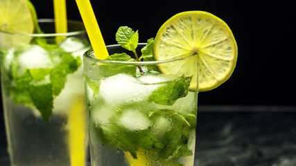 Mojito cocktail with lime and mint in glass on a grey stone background. Close up