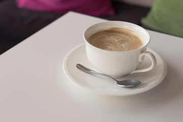 hot coffee in white cup tree shape foam with silver spoon on wooden table at coffee time / hot coffee