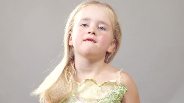A little girl combs her white hair. in the room a soft smooth light.
