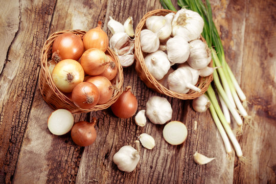 Organic onion, spring onion and garlic on table 