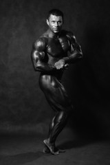 Fototapeta na wymiar Muscular male Bodybuilder posing in studio