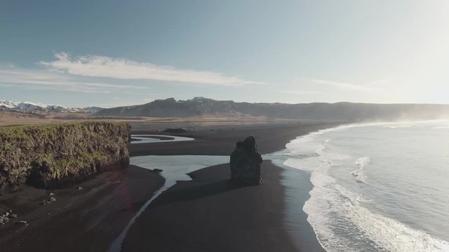 Drone footage of beautiful Reynisfjara beach with long basalt sea stack in Iceland
