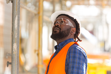 African american engineer looking upwards among scaffolding