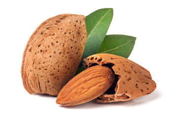almonds in their skins and peeled with leaf isolated on white background
