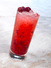 Gold drink with ice. Photographed on a light wooden background. Light illumination.