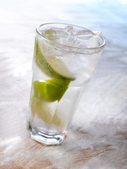 Gold drink with ice. Photographed on a light wooden background. Light illumination.