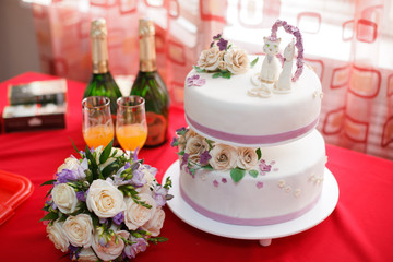 Obraz na płótnie Canvas Wedding mastic cake decorated with flowers and cat figures, closeup