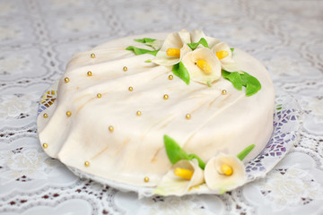 Obraz na płótnie Canvas White mastic cake decorated with flowers, closeup