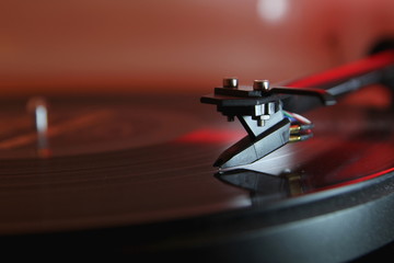 Modern high quality turntable record player playing a vinyl analogue music LP with red back light