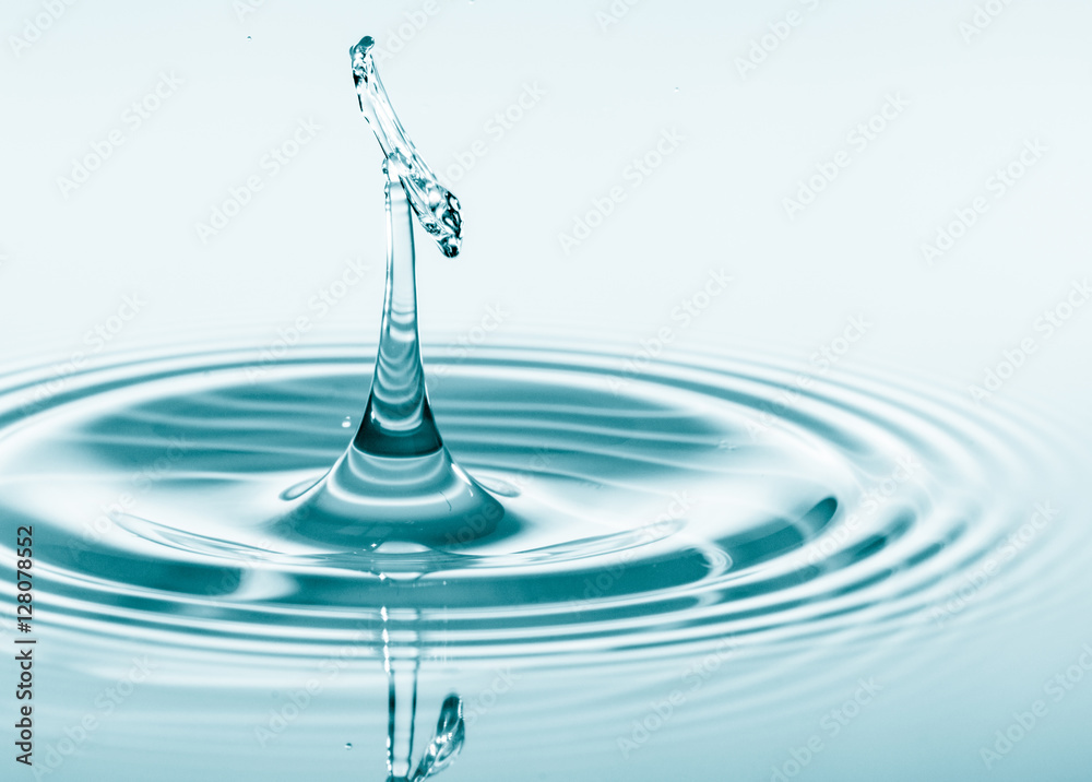 Wall mural water drop falling and drips on water mirror. water drop splash and make perfect circles on water su