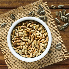 Geröstete Sonnenblumenkerne in kleiner Schüssel, fotografiert mit natürlichem Licht (Selektiver Fokus, Fokus auf die obersten Kernen in der Schüssel)