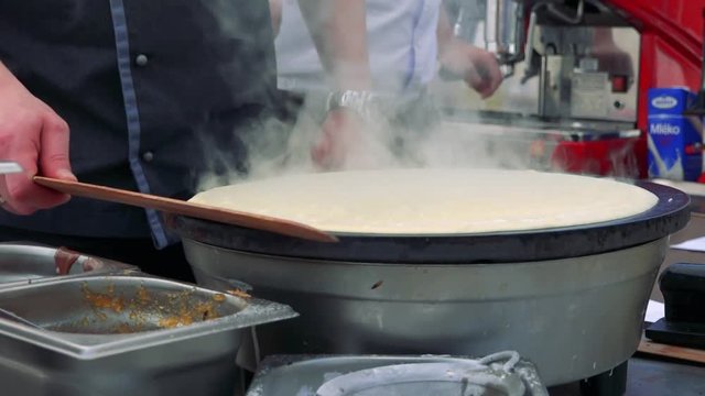 A pancake fries on a hot plate
