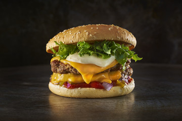 Double cheese burger. Photographed in a metal dark background. Space background. Home made burger.
