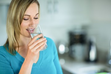 Pretty blonde woman drinking a glass of water
