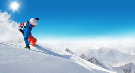 Fototapeta na wymiar Freeride skier on piste running downhill