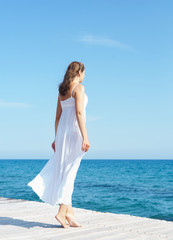 Fototapeta na wymiar Woman in a white dress on a wooden pier