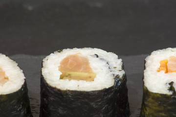 Pieces of sushi on a black stone