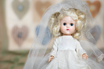 Fototapeta premium Vintage old antique doll that is dressed as a bride with veil. She is from the 40's era.