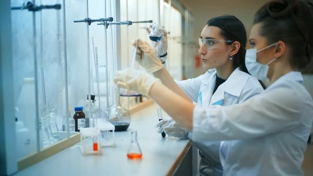Two young female scientist doing experiments in lab