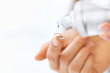 Woman Hand With Contact Eye Lens And Cleansing Solution
