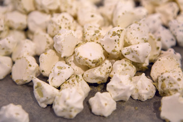 small white meringues with poppy seeds on a gray background