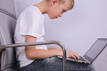 Children bad incorrect sitting posture. Boy using laptop computer - obrazy, fototapety, plakaty