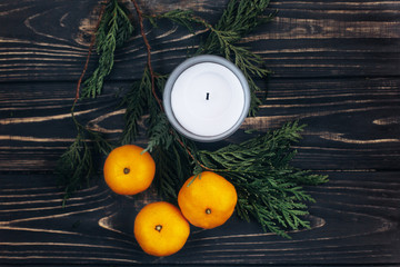 stylish christmas flat lay with green branches and oranges on bl