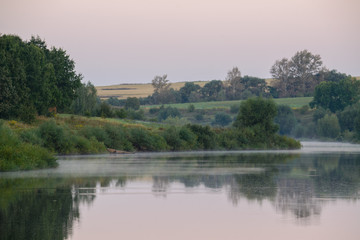 Fototapeta na wymiar Foggy sunrise on the banks of a river in Polesie